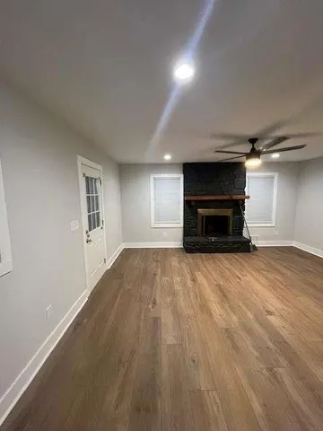 a view of empty room with wooden floor and fireplace