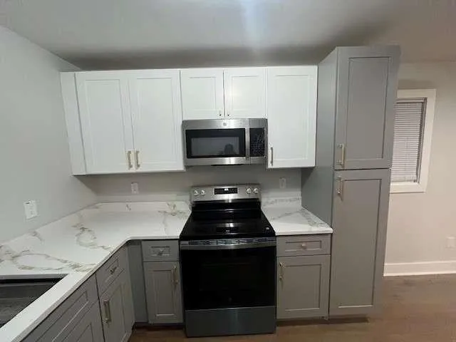 a kitchen with white cabinets and black appliances
