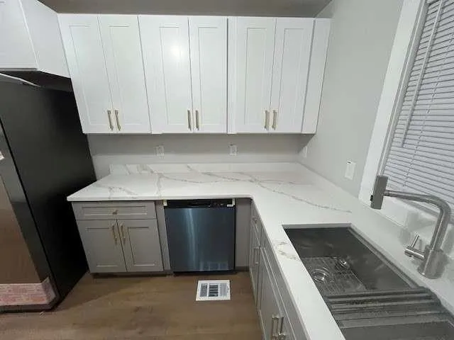 a kitchen with granite countertop a sink a stove and a refrigerator