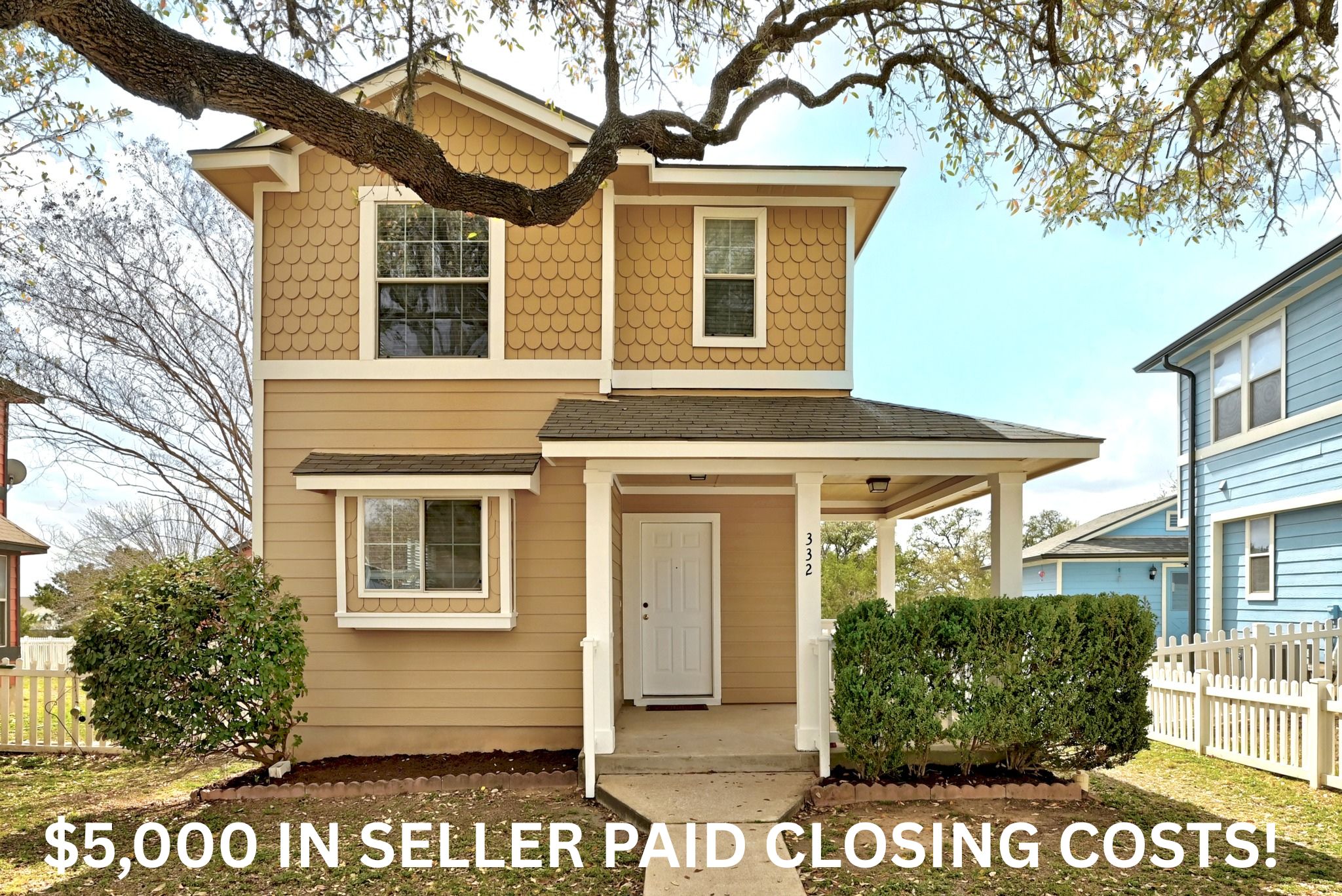a front view of a house with a tree