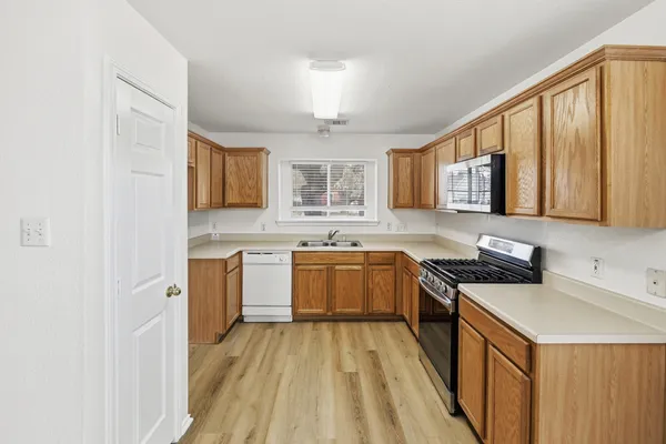 a kitchen with a sink a counter top space cabinets and stainless steel appliances