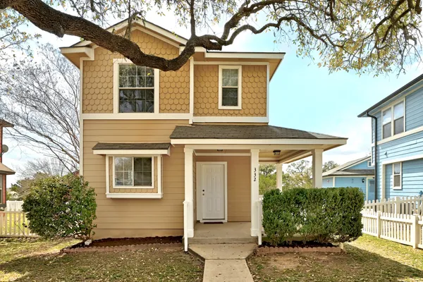a front view of a house with a tree
