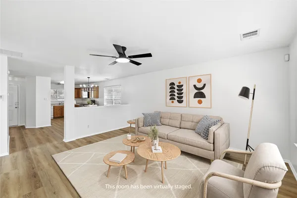 a living room with furniture and a wooden floor