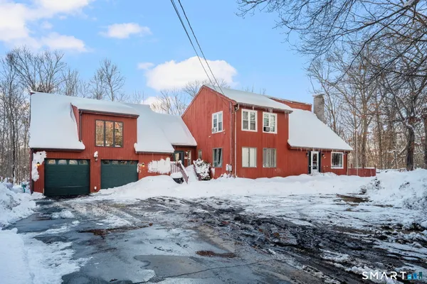 a view of a house with a yard covered in snow