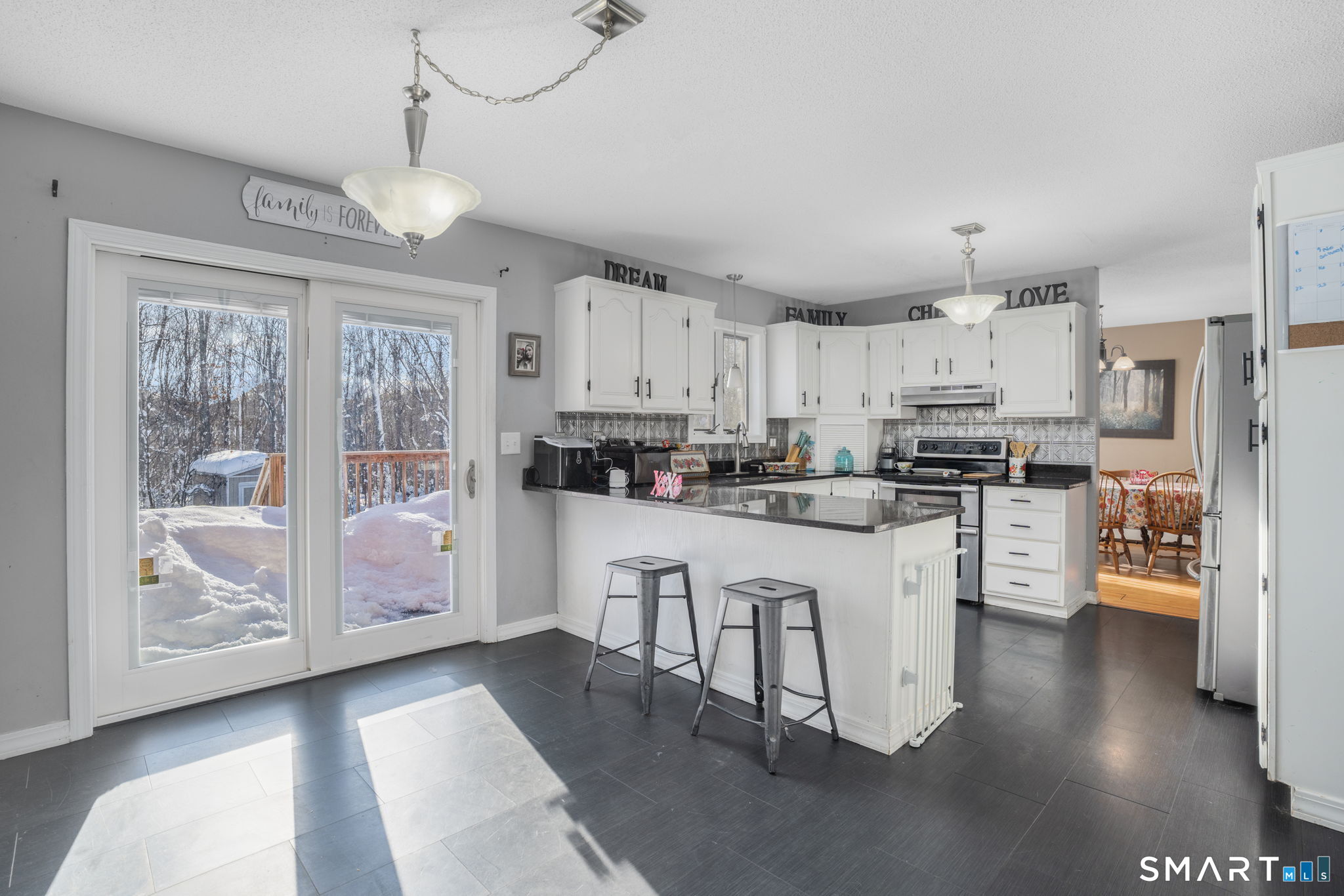 83 Kate Downing Road Plainfield, CT 06374 - Photo 13 of 40 a kitchen with stainless steel appliances kitchen island granite countertop a refrigerator a stove a sink and white cabinets with wooden floor