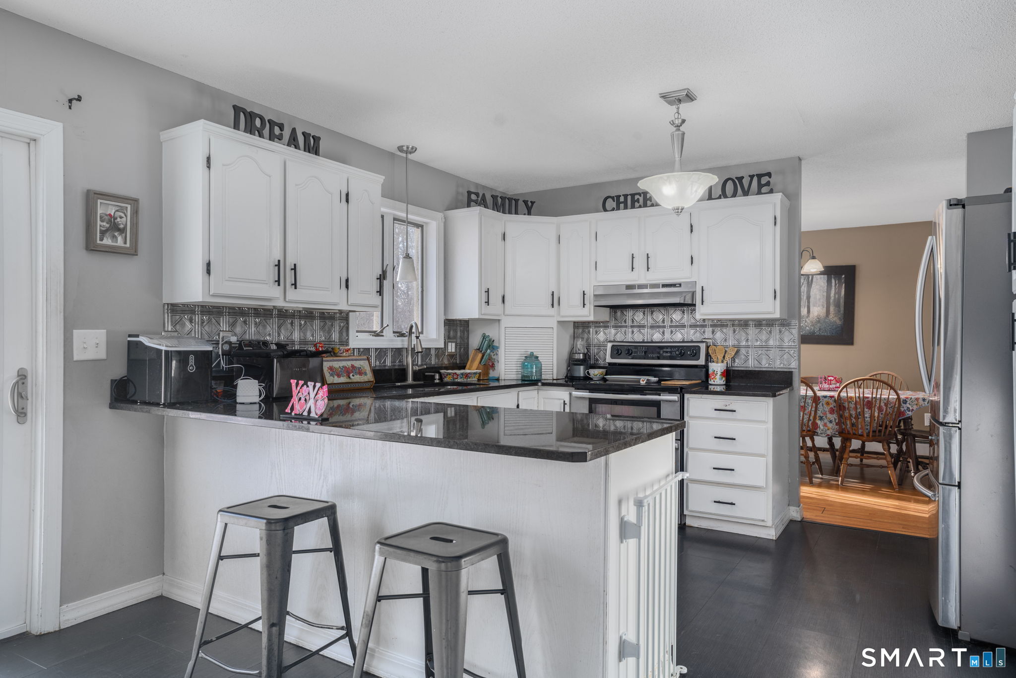 83 Kate Downing Road Plainfield, CT 06374 - Photo 16 of 40 a kitchen with stainless steel appliances granite countertop a stove top oven a refrigerator a sink and dishwasher with white cabinets