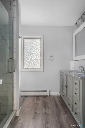 a bathroom with a granite countertop sink toilet and shower