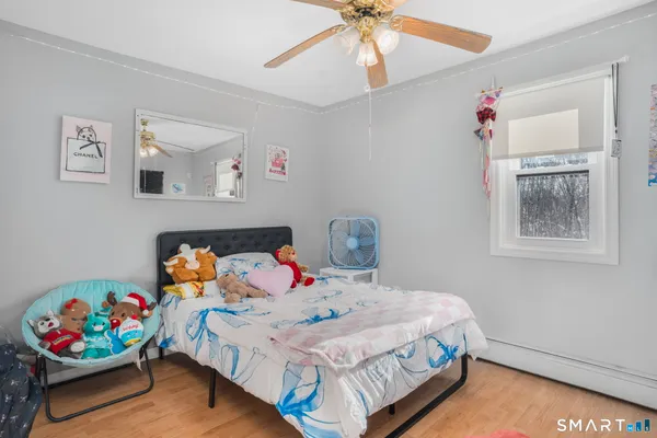 a bedroom with bed and wooden floor
