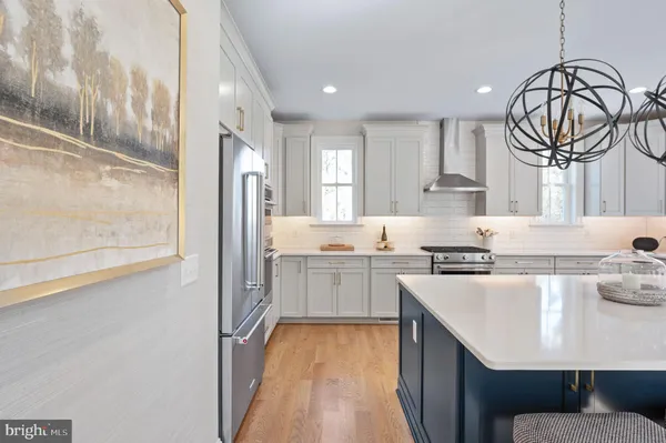a kitchen with a refrigerator a sink and a stove top oven