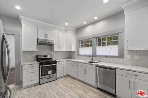 a kitchen with stainless steel appliances a sink stove and refrigerator