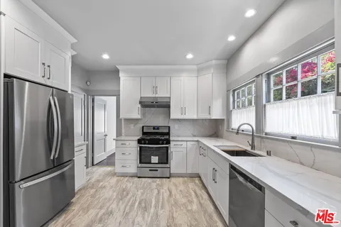 a kitchen with stainless steel appliances a refrigerator sink and microwave