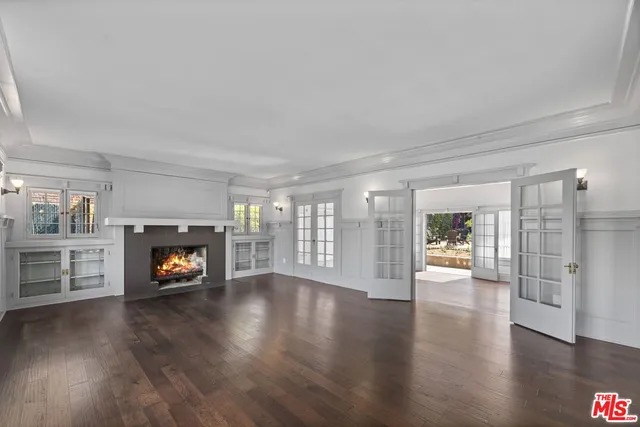 a view of an empty room with a fireplace and a window