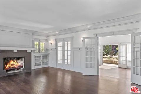 a view of an empty room with a window and fire place