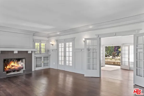 a view of an empty room with a window and fire place