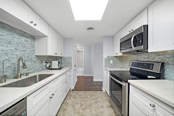 a kitchen with stainless steel appliances granite countertop a sink and stove top oven