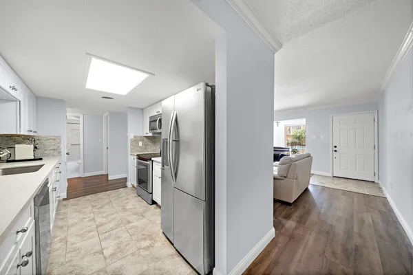 a kitchen with refrigerator a sink and wooden floor