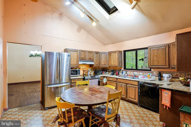a kitchen with stainless steel appliances granite countertop a sink refrigerator and cabinets