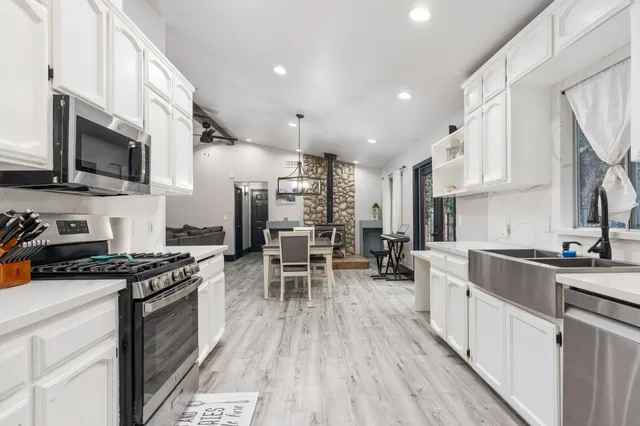 a kitchen with stainless steel appliances a stove sink microwave and cabinets