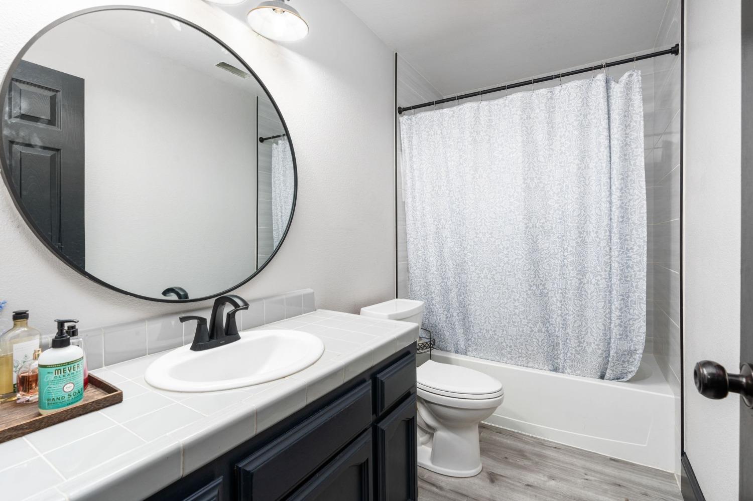 36345 Mudge Ranch Road Coarsegold, CA 93614 - Photo 19 of 51 a bathroom with a granite countertop sink toilet a mirror and shower