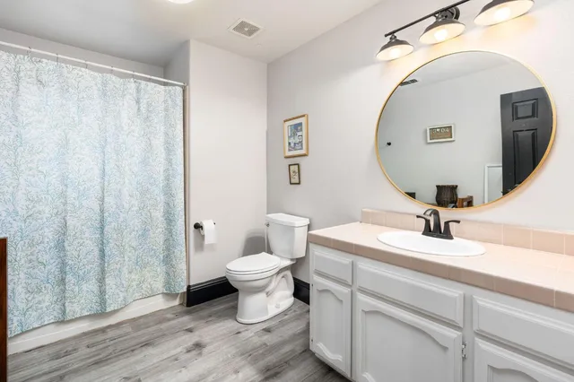 a bathroom with a sink mirror vanity and toilet