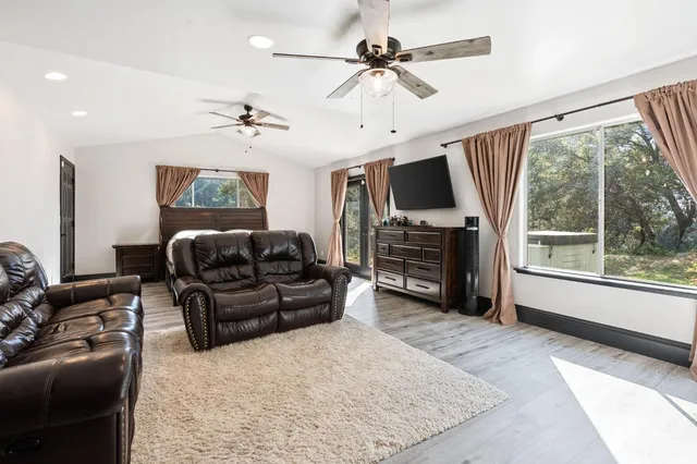 a living room with furniture a flat screen tv and a large window