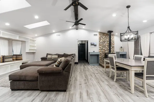 a living room with furniture kitchen view and a wooden floor