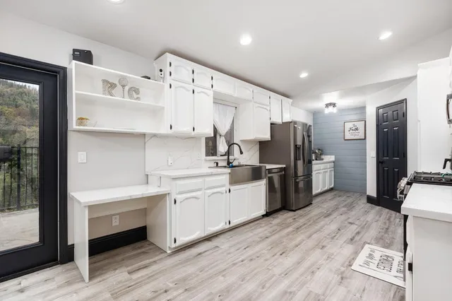 a kitchen with refrigerator a sink and wooden cabinets