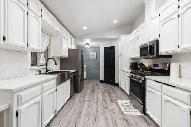 a large kitchen with stainless steel appliances granite countertop a stove a sink and a refrigerator