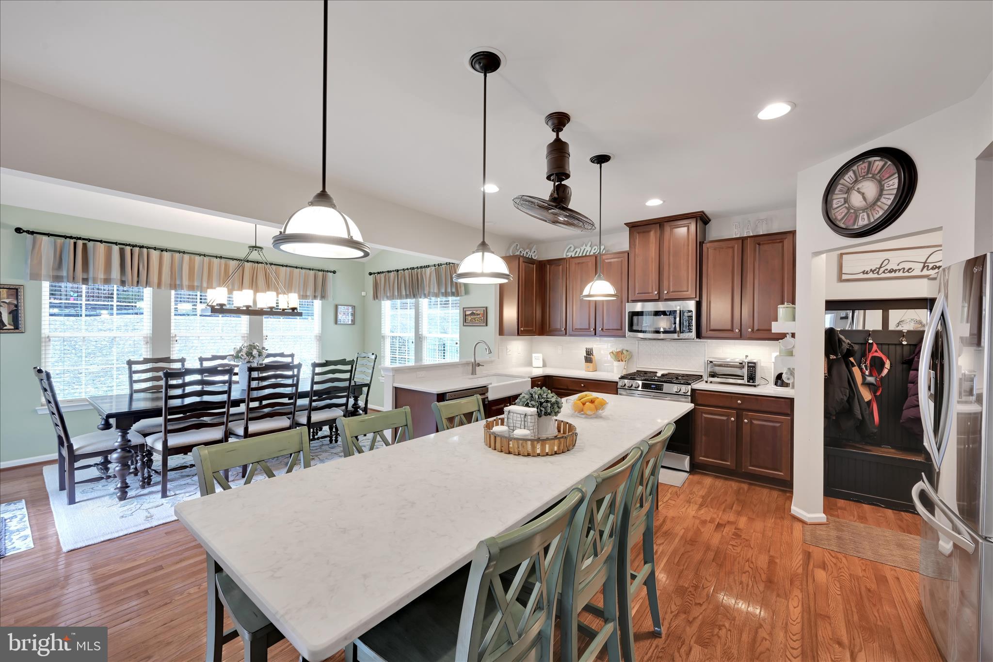1021 Countryside Road Seven Valleys, PA 17360 - Photo 11 of 36 a kitchen with stainless steel appliances granite countertop a stove a refrigerator a dining table and chairs with wooden floor