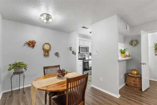 an empty room with wooden floor fireplace and windows