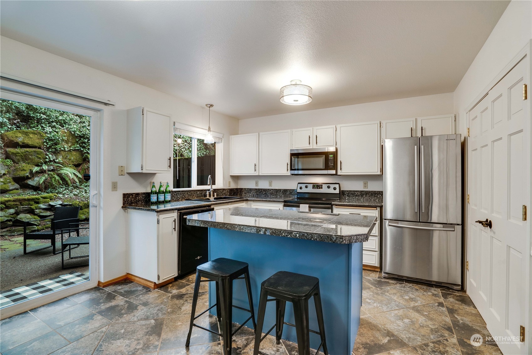 203 View Road Steilacoom, WA 98388 - Photo 6 of 22 a kitchen with kitchen island a refrigerator stove and microwave