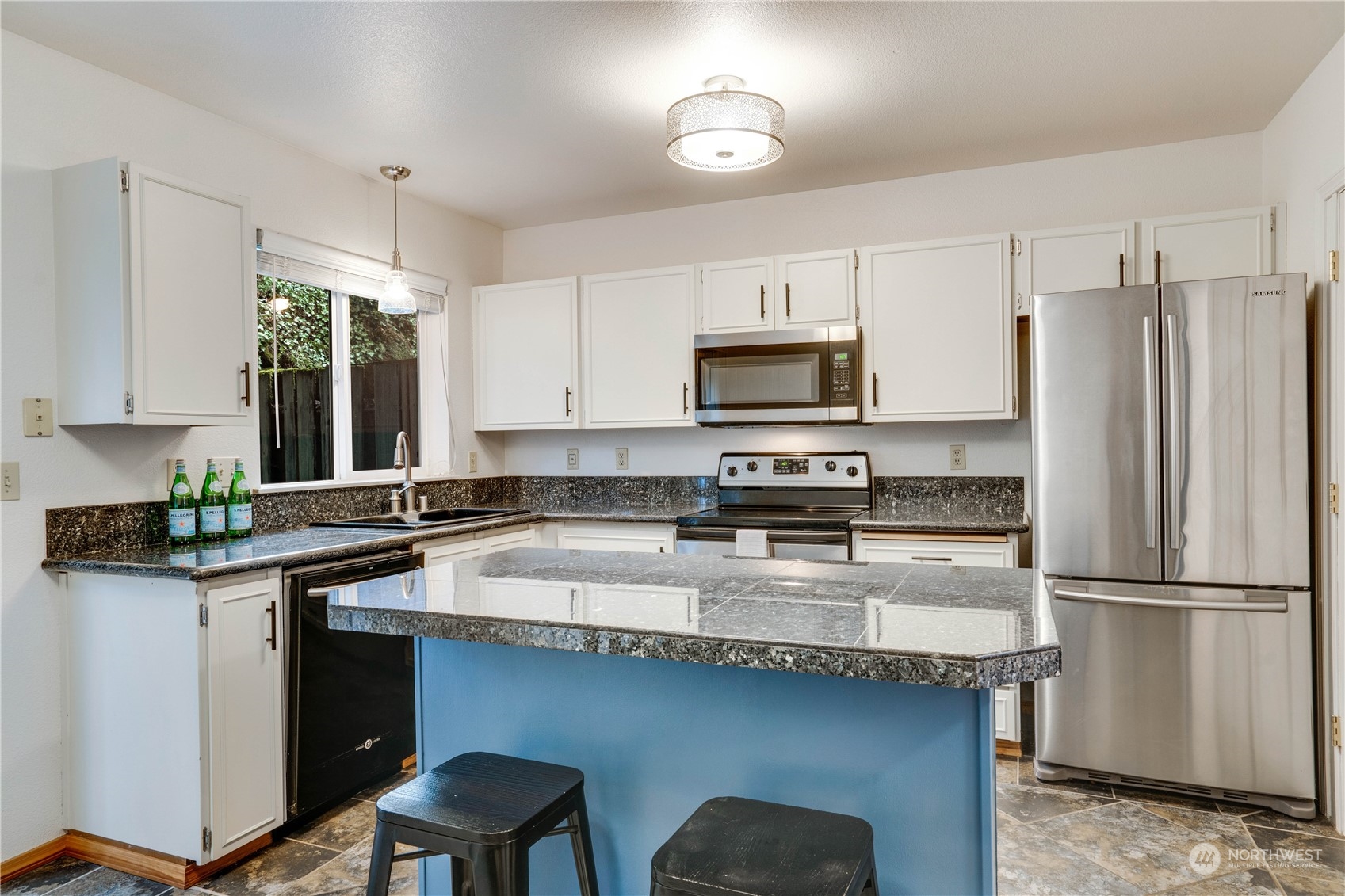 203 View Road Steilacoom, WA 98388 - Photo 7 of 22 a kitchen with stainless steel appliances granite countertop a stove a sink a refrigerator a microwave and cabinets