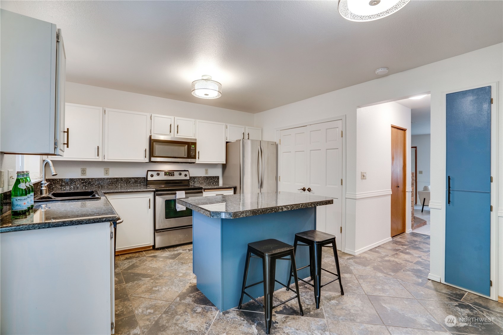 203 View Road Steilacoom, WA 98388 - Photo 8 of 22 a kitchen with stainless steel appliances granite countertop a stove top oven a refrigerator a sink and dishwasher with white cabinets