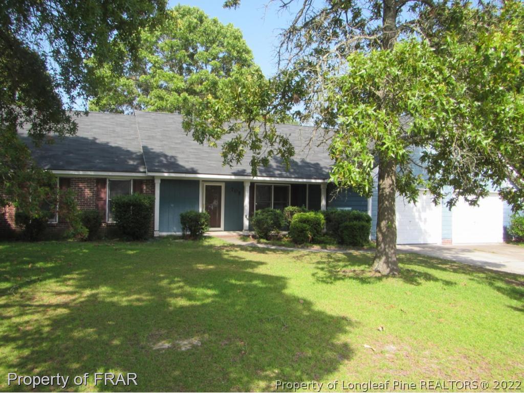 705 Rim Road Fayetteville, NC 28314 - Photo 1 of 26 a backyard of a house with table and chairs plants and large tree