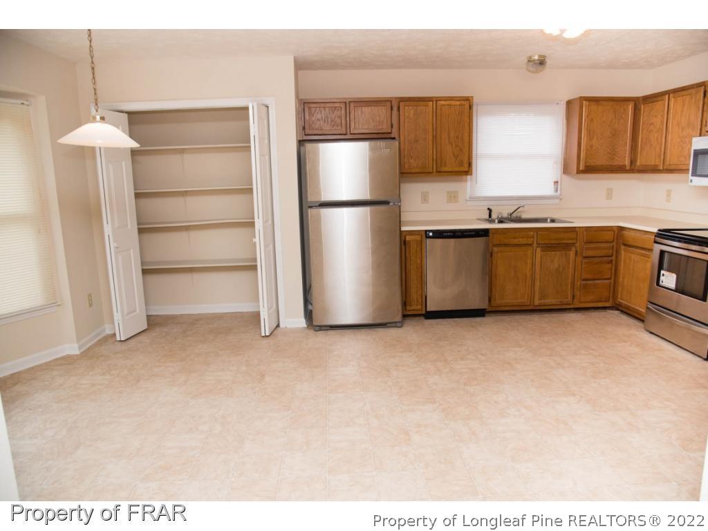 705 Rim Road Fayetteville, NC 28314 - Photo 5 of 26 a kitchen with a refrigerator and cabinets