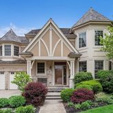 a front view of a house with a yard and potted plants