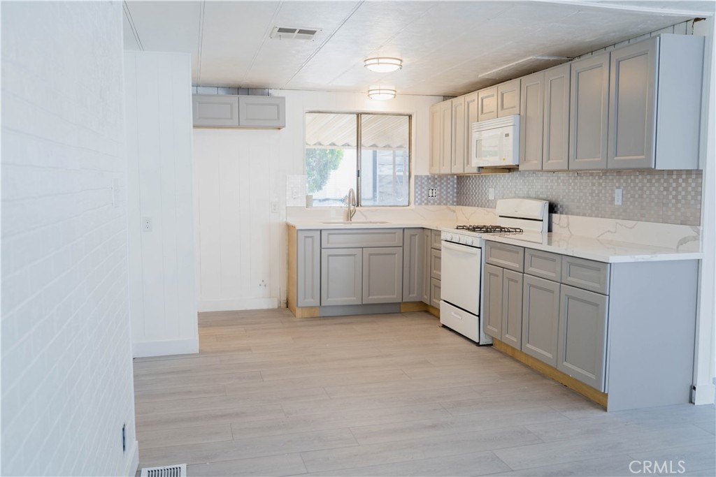 995 Pomona Road, Unit 33 Corona, CA 92882 - Photo 5 of 25 a kitchen with white cabinets appliances a sink and a window
