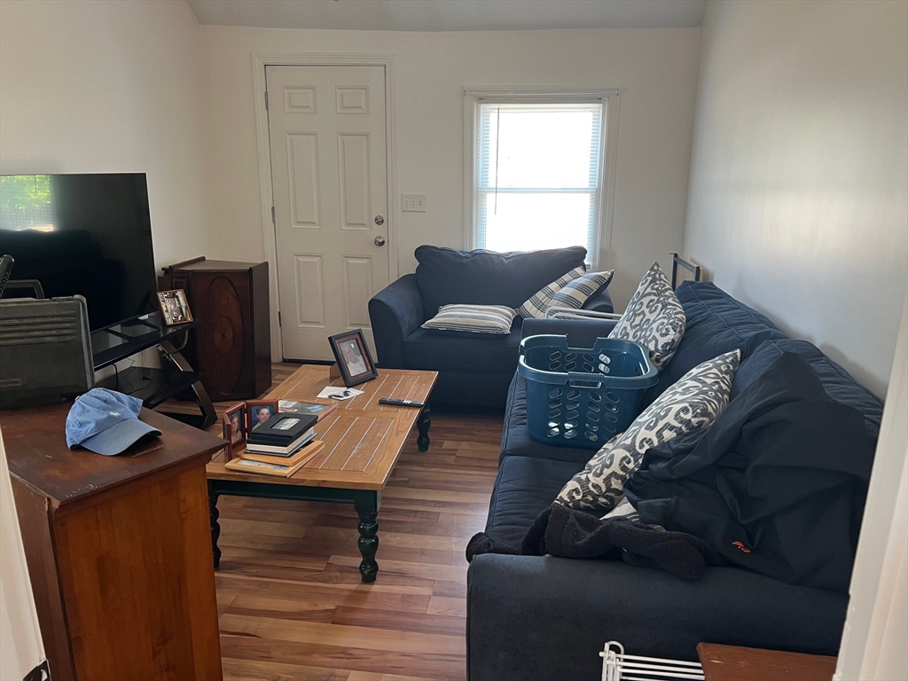 151-153 Main Street Bourne, MA 02532 - Photo 12 of 14 a living room with furniture and a flat screen tv