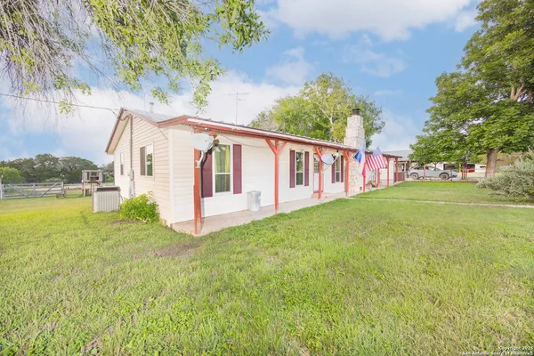 a view of a house with backyard and sitting area