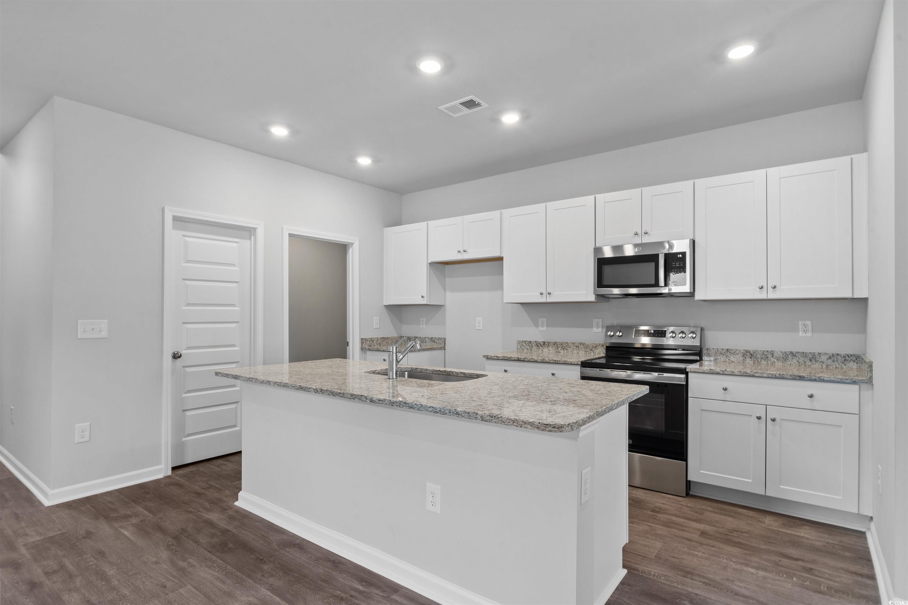 409 Ribbon Rail Way Loris, SC 29569 - Photo 6 of 39 Kitchen with white cabinets, sink, an island with