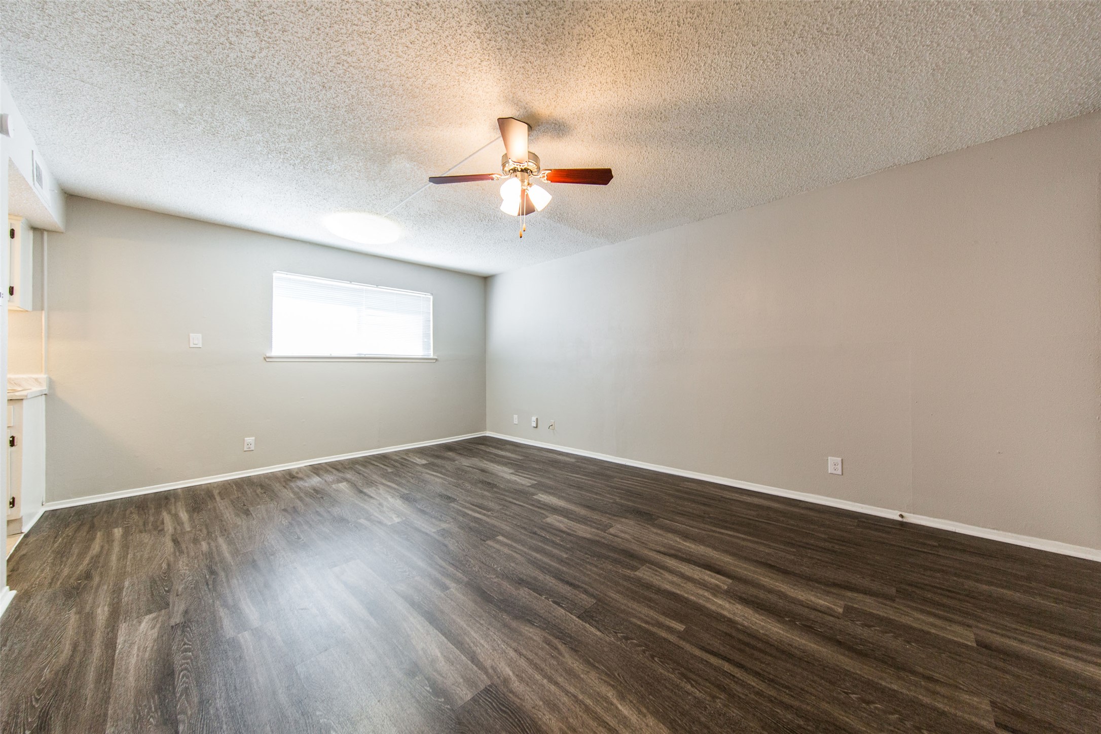 108 West 45th Street, Unit 110 Austin, TX 78751 - Photo 4 of 7 Spare room featuring a textured ceiling, dark wood-style floors, and a ceiling fan