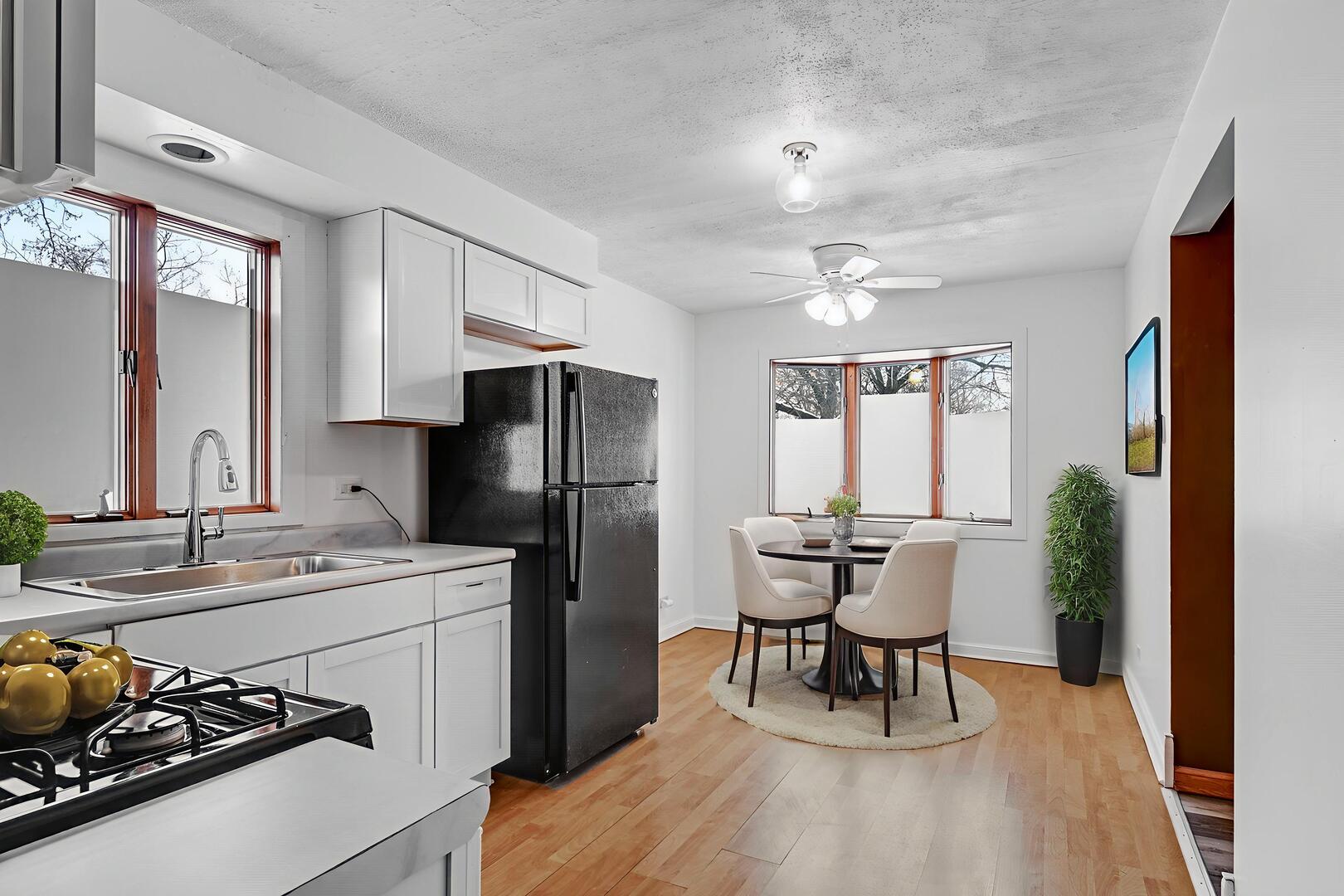 3740 153rd Street Midlothian, IL 60445 - Photo 4 of 20 a kitchen with stainless steel appliances a dining table chairs refrigerator and sink