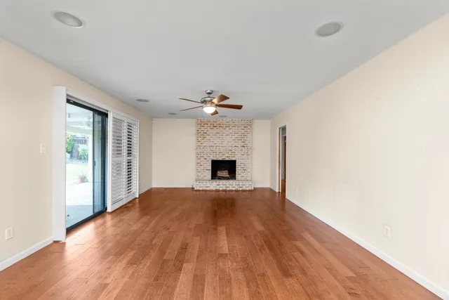 a view of empty room with wooden floor and fireplace