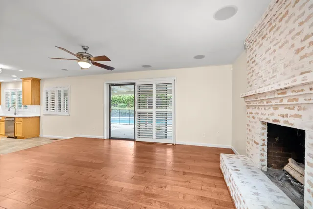 a view of an empty room with a fireplace and a window