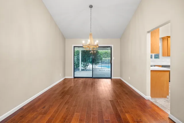 a view of a room with wooden floor a ceiling fan and a window