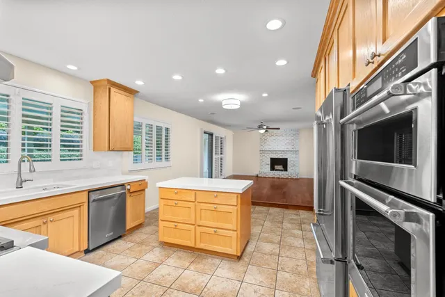 a large kitchen with stainless steel appliances granite countertop a sink and cabinets