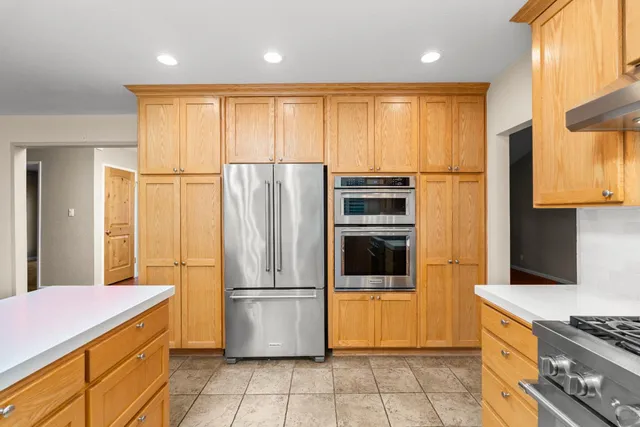 a kitchen with stainless steel appliances granite countertop a refrigerator a stove and a sink