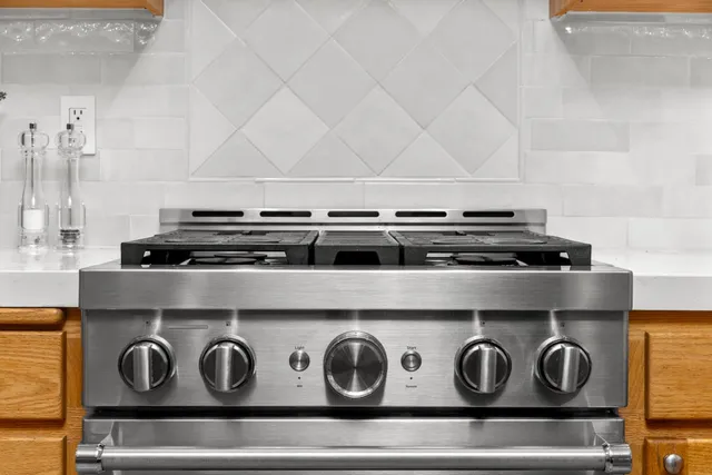 a stove top oven sitting inside of a kitchen