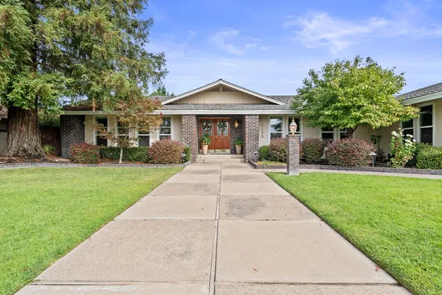 a front view of a house with yard and green space