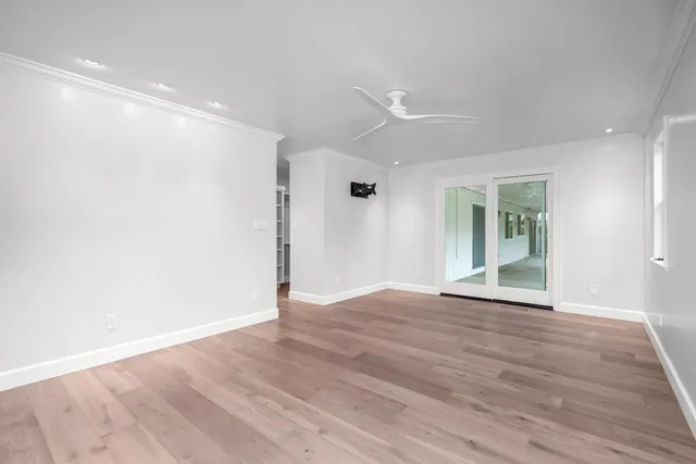 a view of an empty room with wooden floor